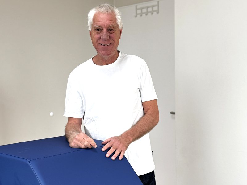 Hans-Martin Loga steht lächelnd hinter einer Behandlungsliege